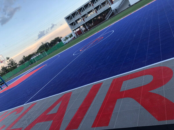 Cancha deportiva azul con gráficos en rojo